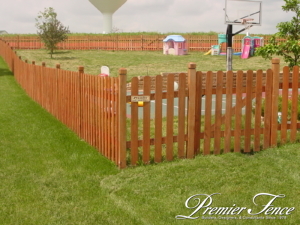 Western red cedar picket fence around backyard to contain kids while they play
